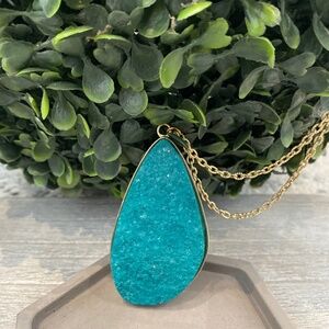 Striking large druzy pendant features a vibrant turquoise hue